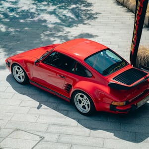 A vintage red sports car parked outdoors in Southampton, UK under bright sunlight.